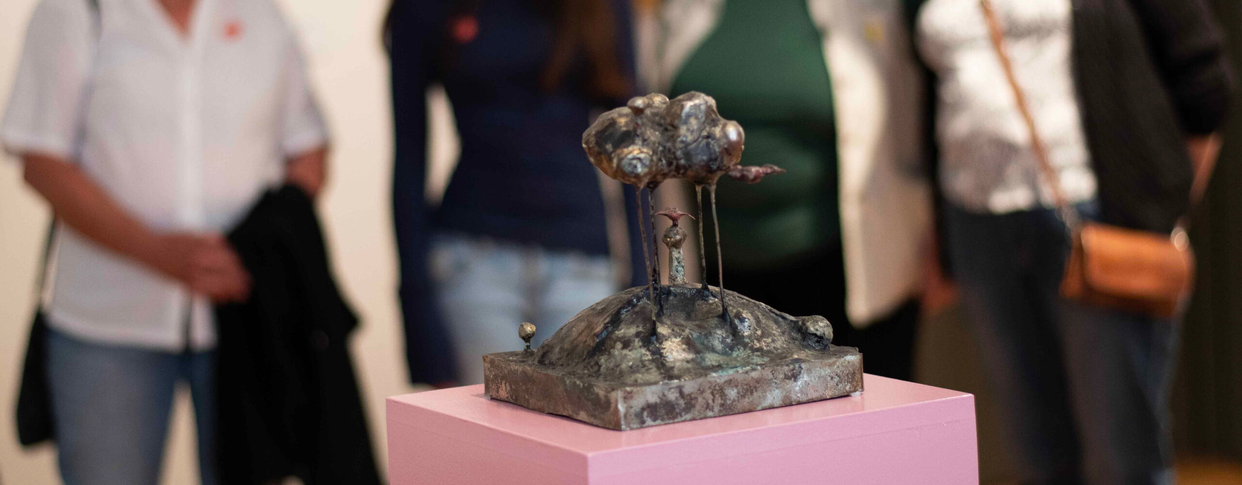 Skulpturen Molnet och Tylajungfrun av Jan Åberg. Besökare på Hallands Konstmuseum står runtomkring och tittar på den.