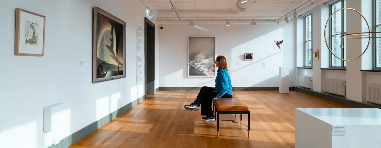 Besökare som betraktar konstverk i utställningen Ur samlingen.