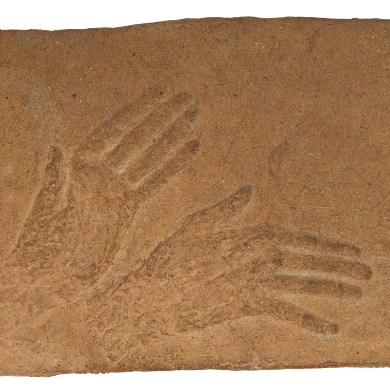 Relief i lera med motiv av två händer.